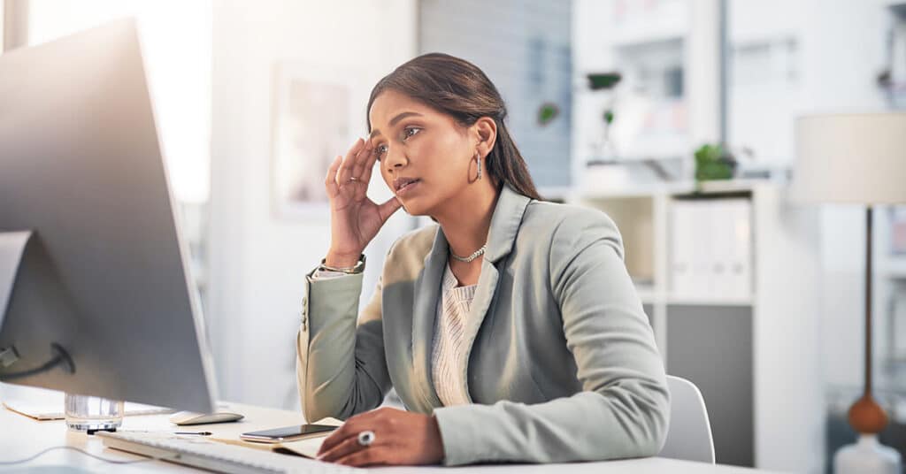 business woman overwhelmed at computer, evoking change management