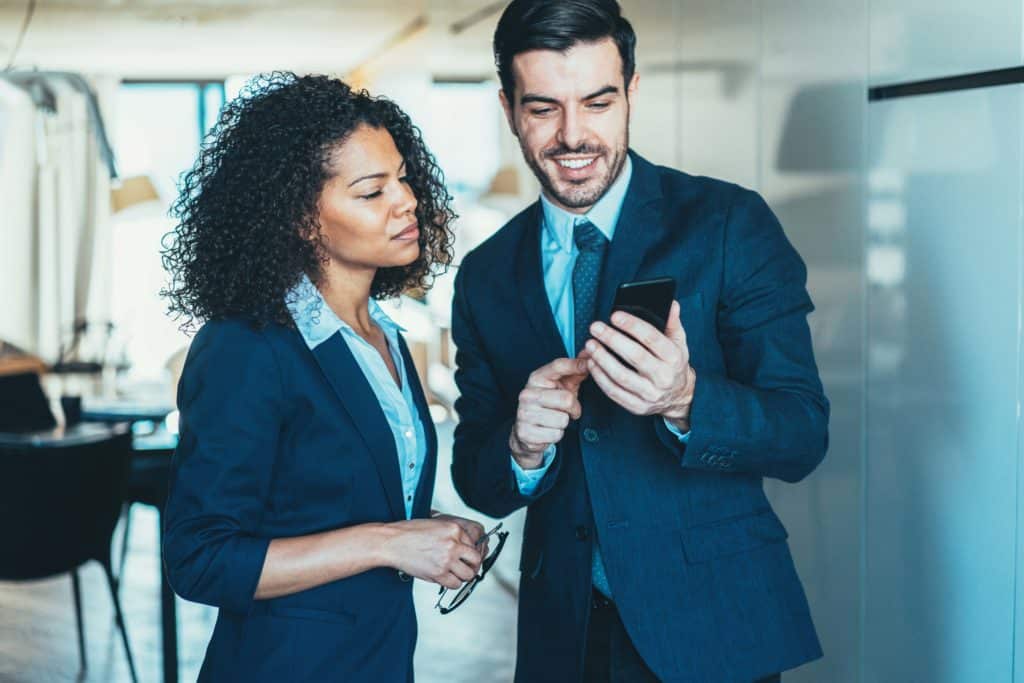 business people in office looking at a phone evoking CPD Company-Provided Device
