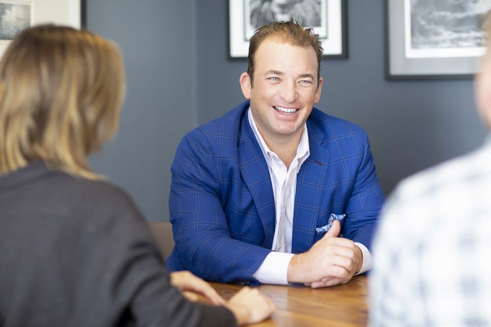 Laughing man facing two other people