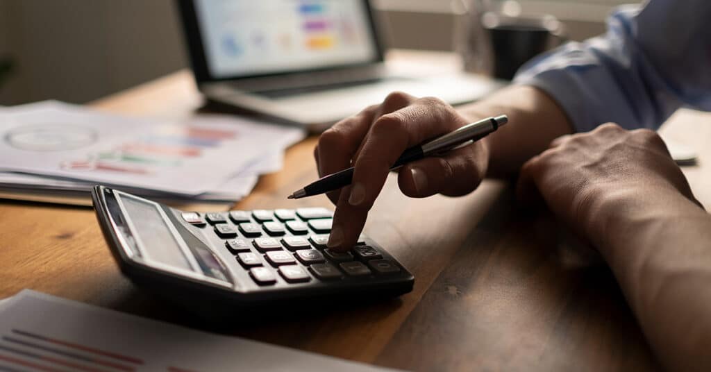 business man using calculator evoking irs mileage rate