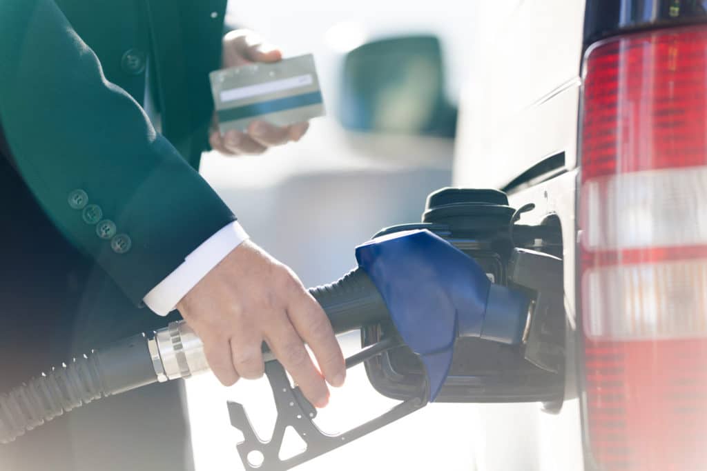 Hand filling a car with gas
