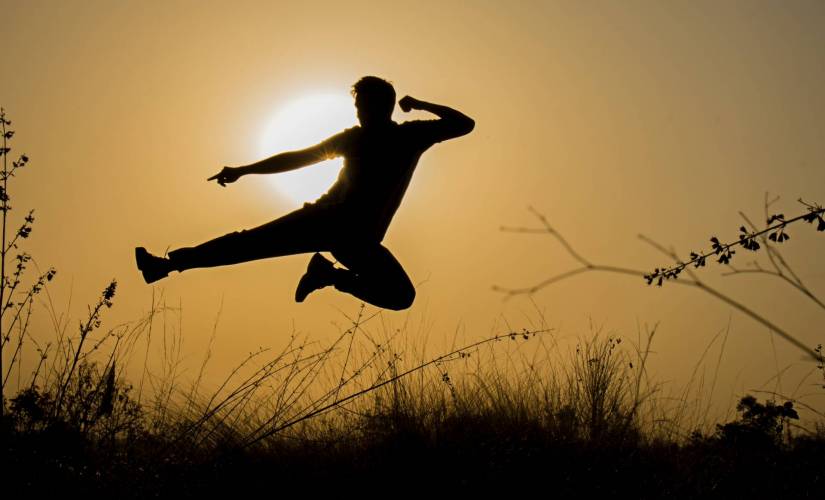 Silhouette of a person in midair in a fight pose
