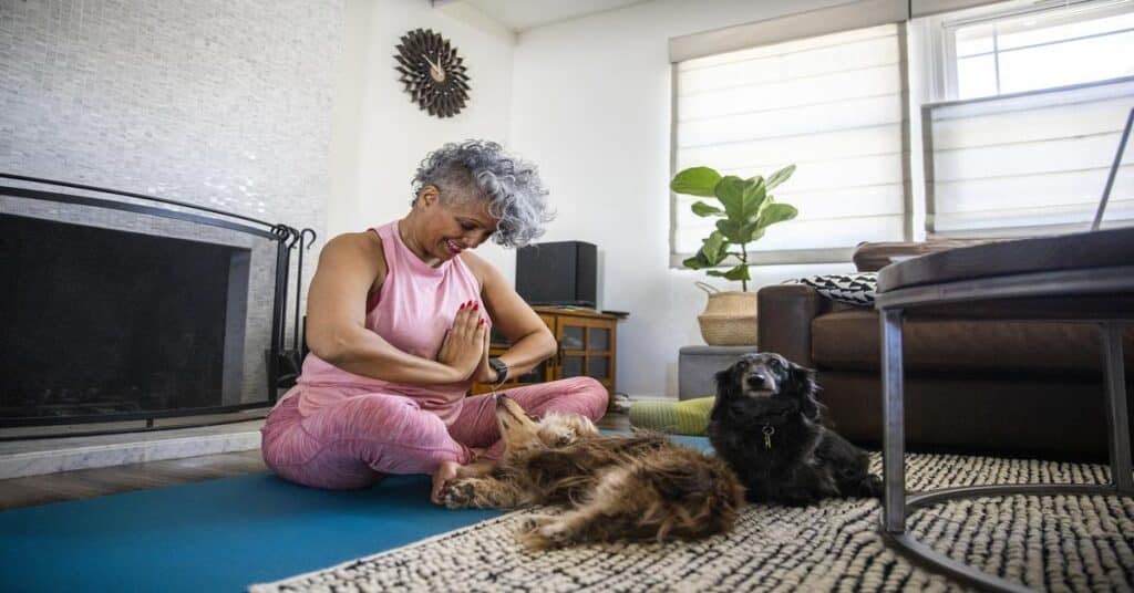 woman doing yoga with puppies evoking modern health