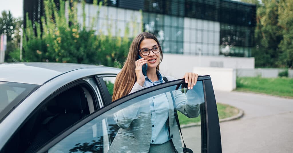 business woman on her phone leaving her vehicle evoking Personal Asset Reimbursement