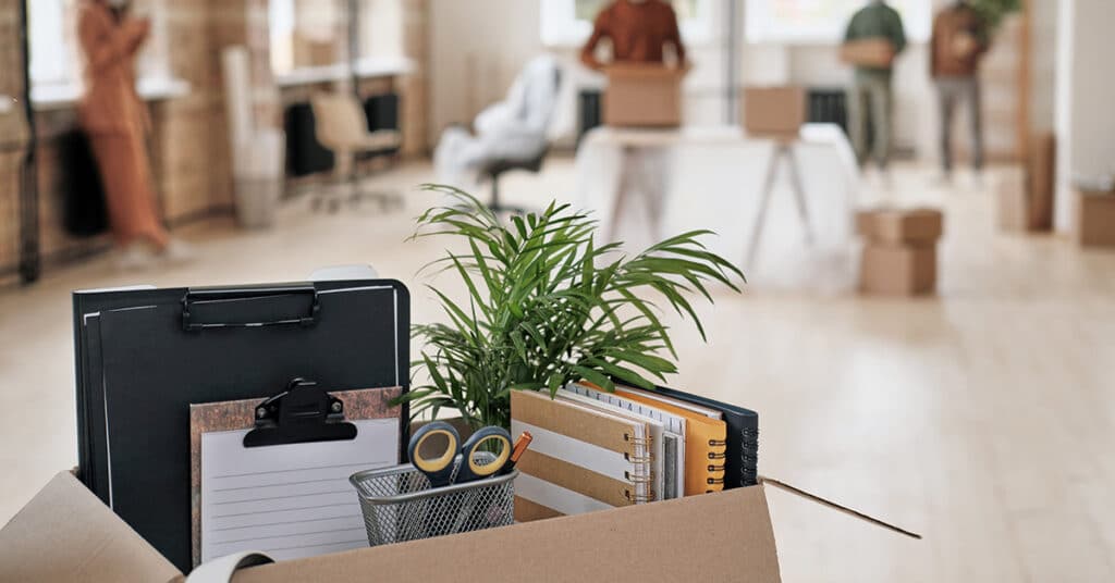 office supplies in moving box evoking return to office