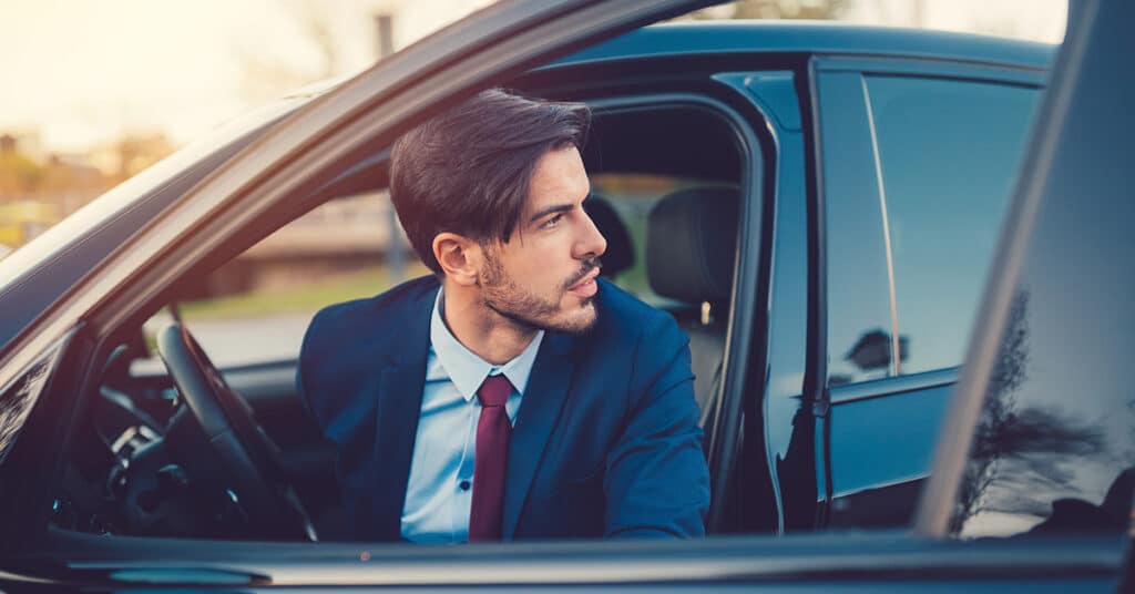 business man getting out of vehicle evoking transitioning out of a cents-per-mile program