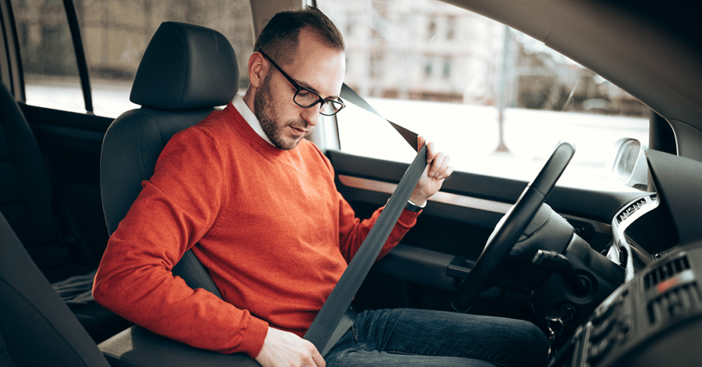 man buckles seatbelt evoking Corporate Driver Safety Training