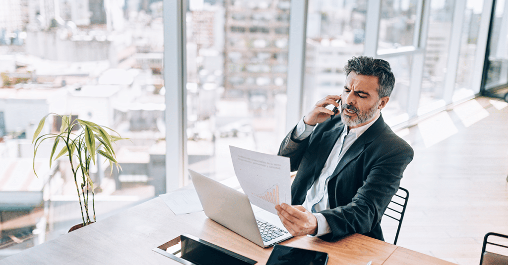 confused businessman looking at paperwork evoking employee reimbursement policy