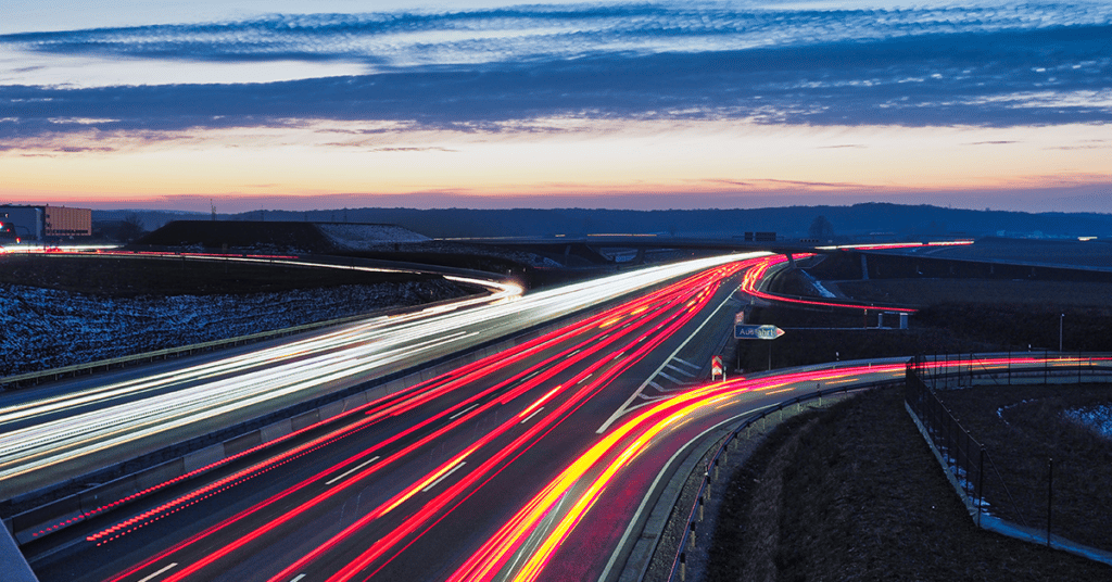 long exposure image of vehicle lights on a highway evoking federal mileage allowance