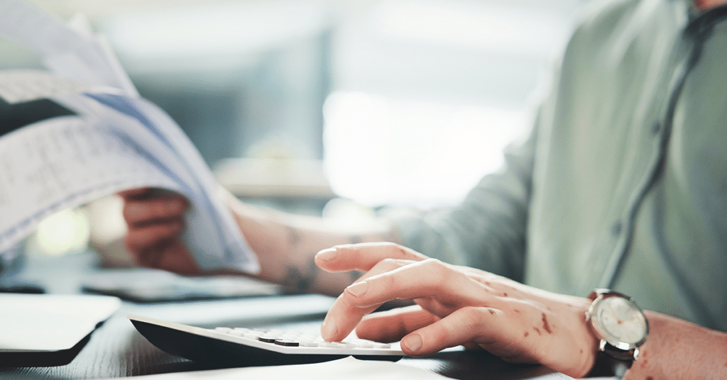 business person using calculator with stack of papers evoking Preventing a Vehicle Program Audit